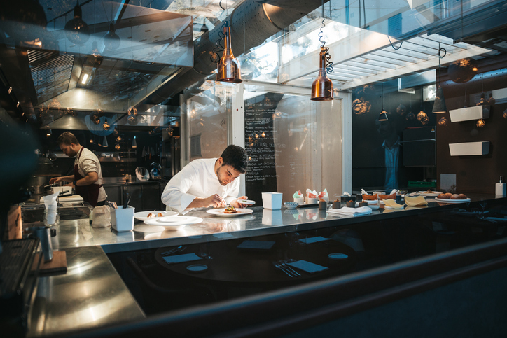 Chef d'un restaurant entrain de dresser un plat avec des produits frais